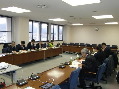 会議室で対面に座る山口県周南市議会の人々と篠山市議会の議員らの写真