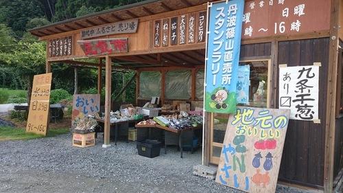 丹波篠山直売所スタンプラリーの旗と手作りの看板が置かれ、様々な農産物が並んだ直売所の写真