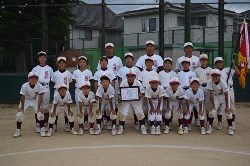 優勝旗と賞状とともに写真に写る味間少年野球団の一同の写真