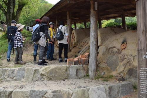石の階段を上った上にある屋根がついた最古の登り窯を見学する来訪者の方々の写真