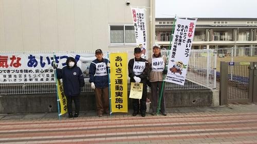 味間こども園前でのぼりを持ってあいさつ運動する男女4人の写真
