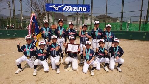 優勝旗と賞状とともに笑顔で写真に写る城南少年野球団の皆さんの写真