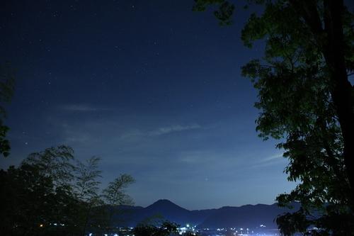 星の瞬く夜空に浮かび上がる綺麗な丘陵の高城山の夜景の写真