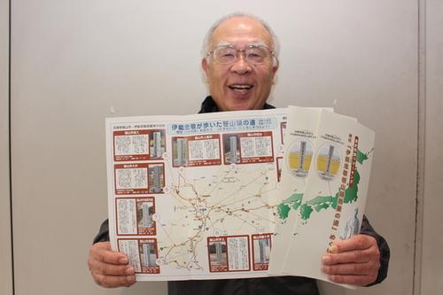 完成したガイドマップを手にする代表の加賀尾宏一さんの写真