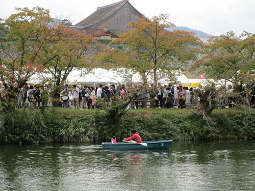 色づき始めた北堀端の桜並木の中、丹波篠山味まつりでにぎわう横を、ゆっくり漕ぐ観光ボートの写真