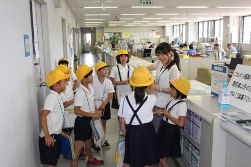 篠山小学校の3年生の生徒たちが市の女性職員から説明を聞いている写真