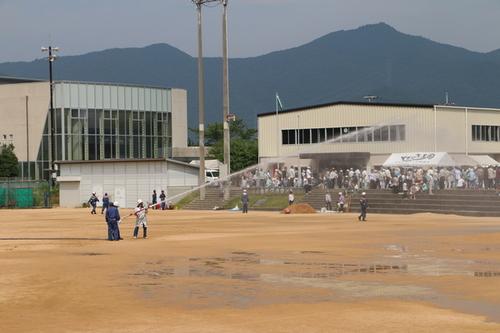 野球場のような広い場所で放水の訓練をしている様子の写真