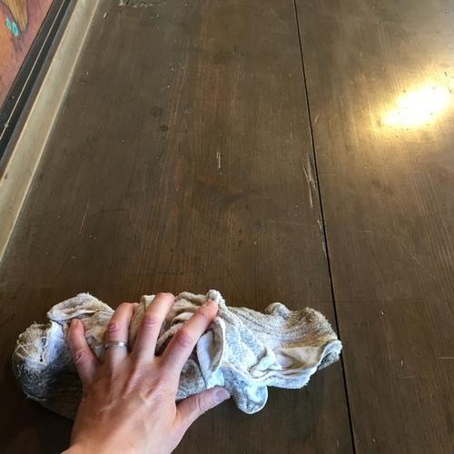 床と、雑巾を持つ手のアップの写真