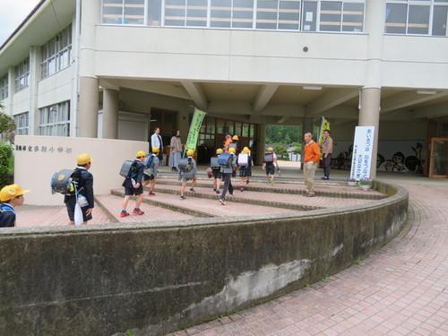 多紀小学校前で階段をのぼって登校する児童達をあいさつで迎える大人達の写真