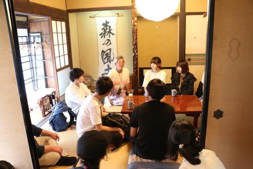 和室で地元住人からお話を聞く参加者たちの写真
