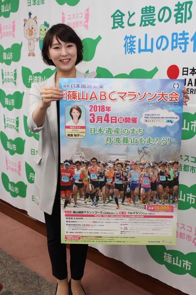 篠山ABCマラソン大会出場者募集ポスターを広げて見せている女性の写真