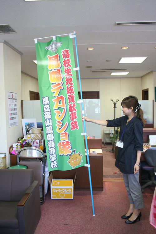 篠山鳳鳴高校が作ったデカンショ祭ののぼり旗を掲げている女性の写真