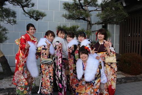 着物を着て笑顔でピースをしている7人の女性たちの写真