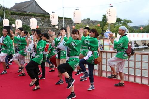 緑色のはっぴを着てデカンショ踊りをする男女たちの写真