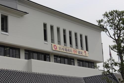 曇り空と白壁に祝とダブルの赤文字が映える日本遺産ダブル認定を記念した横断幕の写真