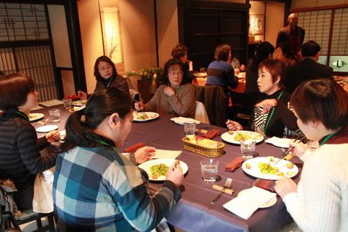 参加女性たちがテーブルを囲み食事をしている様子の写真