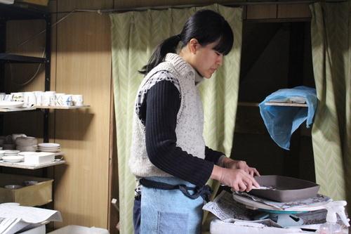 自宅の工房にて、真剣な表情で使いやすいデザインに陶器を仕上げている矢倉藍子さんの写真