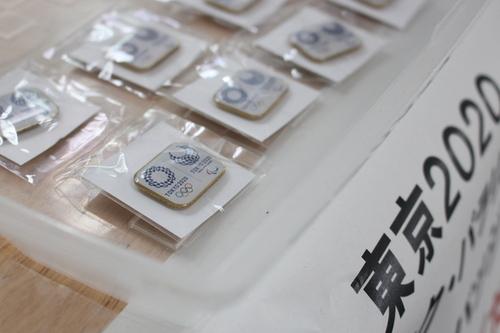 配布されている東京2020オリンピック・パラリンピックの公式バッジが沢山机の上に並べられた写真