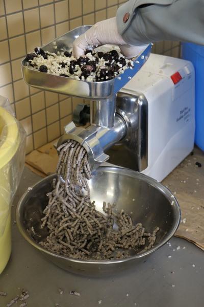 黒豆と塩と麹を混ぜ合わせたものをみそすり機械にかけている様子の写真