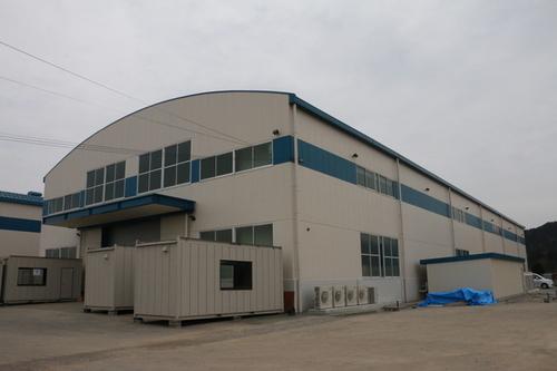 緩く弧を描いた屋根の工場の外観写真