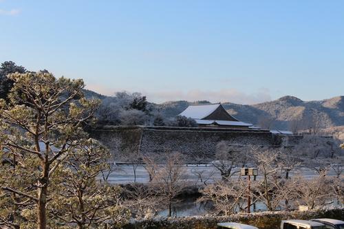 青く澄んだ空の下で薄く降り積もった雪景色の中の篠山城大書院の写真