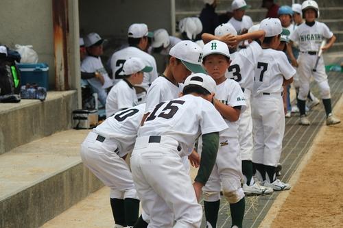 試合中のベンチ前で待機している篠山東野球少年団の選手たちの写真