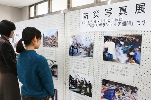 防災写真展と書かれたボードの前で展示された写真を眺めている2名の女性の写真