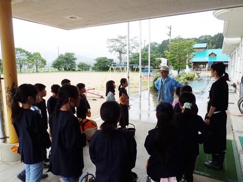 西紀南小学校の生徒たちが講師の堀江溢雄さんから話を聞いている写真