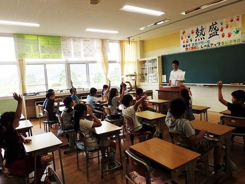 田井先生のクイズに、手を挙げて答えようとしている西紀南小学校4年生の皆さんの写真