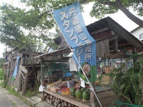丹波篠山直売所スタンプラリーの旗がかかった木造の売店でスイカやトマトが並んだ丹波篠山直売所の写真