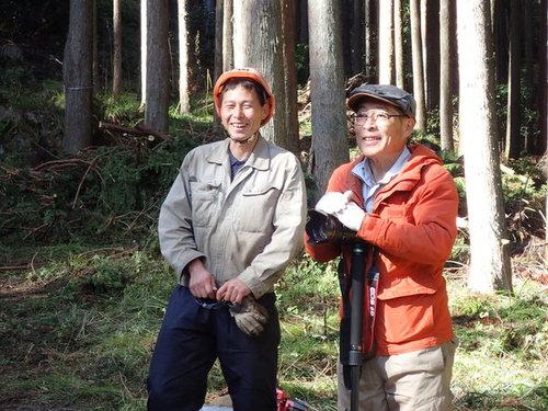 光差し込む森の中で笑みを浮かべる藤本さんと谷本さんの写真
