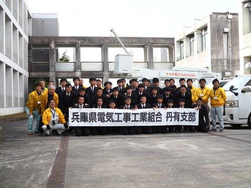「兵庫県電気工事工業組合 丹有支部」の横幕を持つ篠山産業高校電気科32人と組合員16人の集合写真