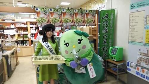 黒枝豆を持ち神戸そごうの店頭に並ぶ尾嶋さんとまめりんの写真