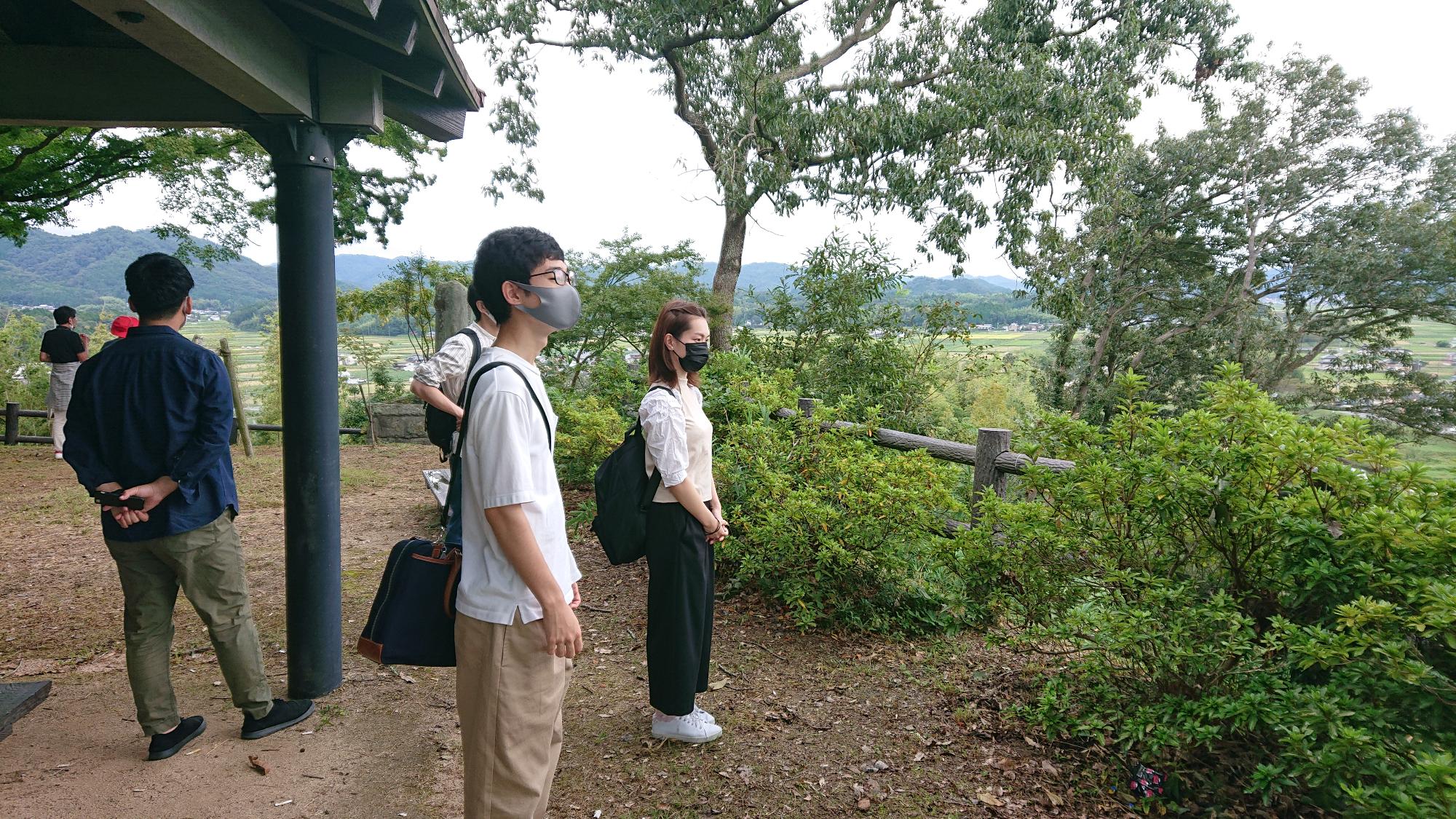 王地山からの眺望を参加者が確認している風景