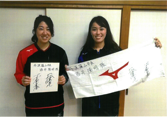 森原さんと深澤さんがそれぞれ色紙とタオルを手に持ち記念写真
