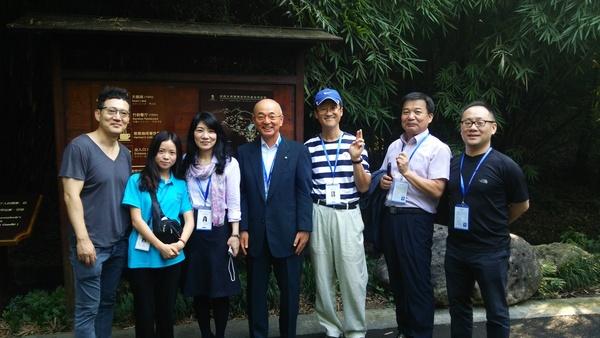 屋外の看板の前に並んで立っている酒井市長と韓国、光州市の6名の写真