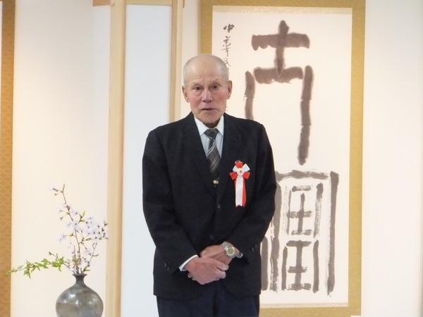 高橋 勝さんが、両手を体の前にかさね、立っている写真