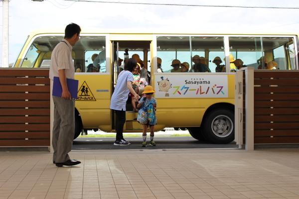 園に到着した子供たちがスクールバスから下りている写真