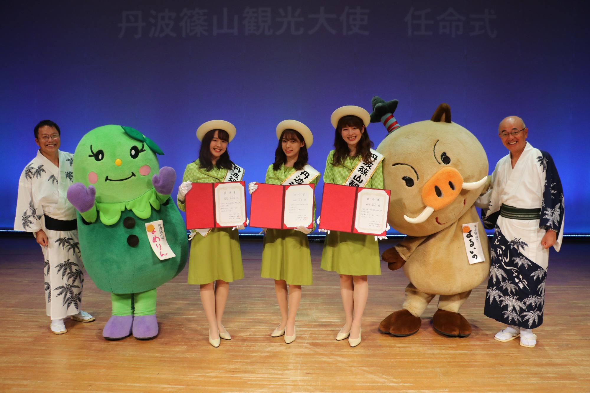 観光大使3人を囲んで、まるいの、まめりん、酒井市長、観光協会会長が記念撮影