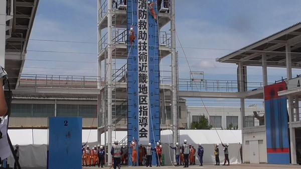 隊員がロープで上まで登っている写真