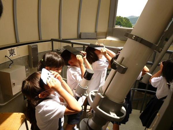 生徒が黒い下敷を持って、天体ドームで星空観測会をしている写真