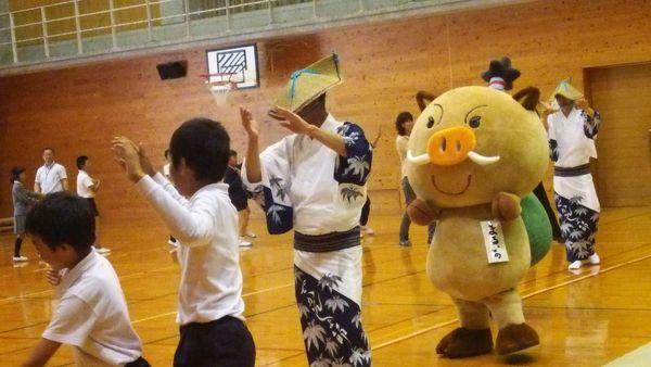 生徒とイメージキャラクターまるいのと浴衣の方が踊っている写真