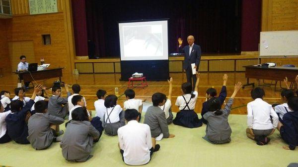 前で市長が挙手していて、座ている多紀小学校生徒達数名が挙手している写真