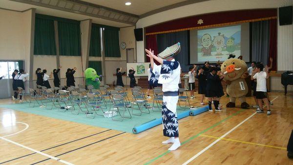 浴衣に花笠の方を先頭にイメージキャラクターまるいのと生徒が踊っている写真