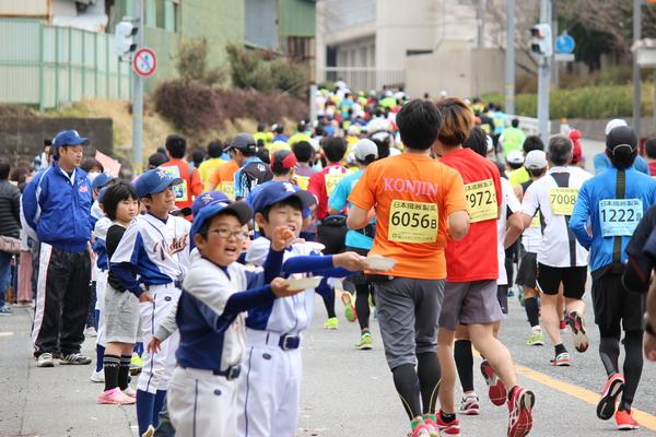 ランナーを指差す、ユニフォーム姿の野球少年団の写真