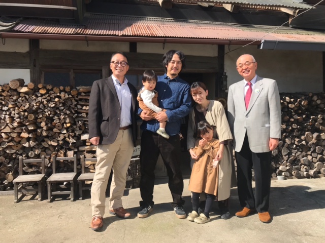 工房の前で、職人の夫婦、お子さん、市長たちが記念撮影