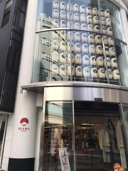 ビームスジャパン会社の外観、入り口にオレンジ色の信楽焼のたぬきの置物が置いてある写真