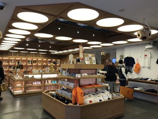 棚に置いてある商品を手にしている眼鏡をかけている男性や、壁にTシャツが飾られており、黒のTシャツを手で触っている後ろ姿の男性の写真