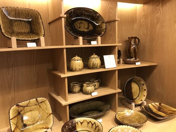様々な器の形をした陶芸作品が飾られている写真