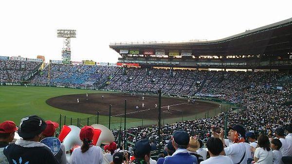 甲子園球場のマウンドに選手達が立っており、観客席に満員のお客さんが応援に詰めかけている様子のグランド全体の写真